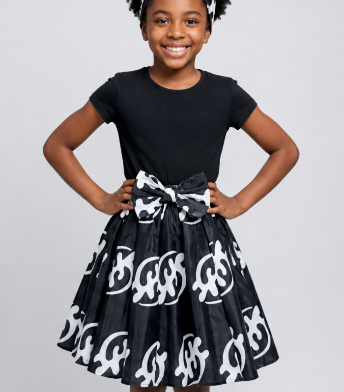 Girl wearing black and white Gye Nyame African print skirt with matching head scarf ages 5–9