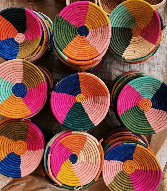 Small handwoven Ugandan basket in orange, navy, olive green, bright pink and black