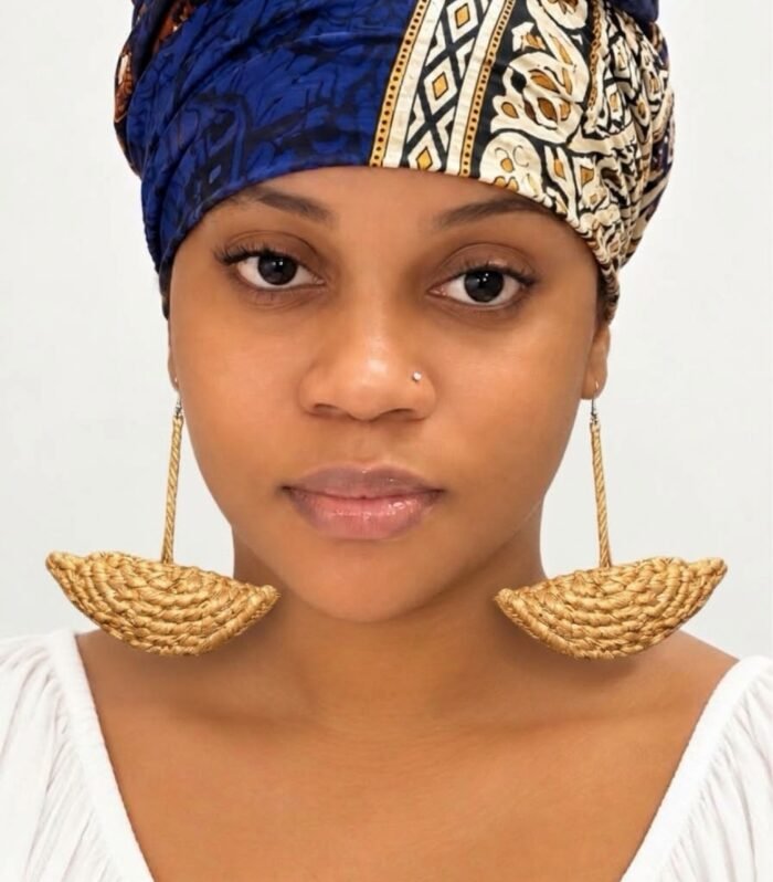 Model wearing natural handwoven raffia half-moon boat earrings